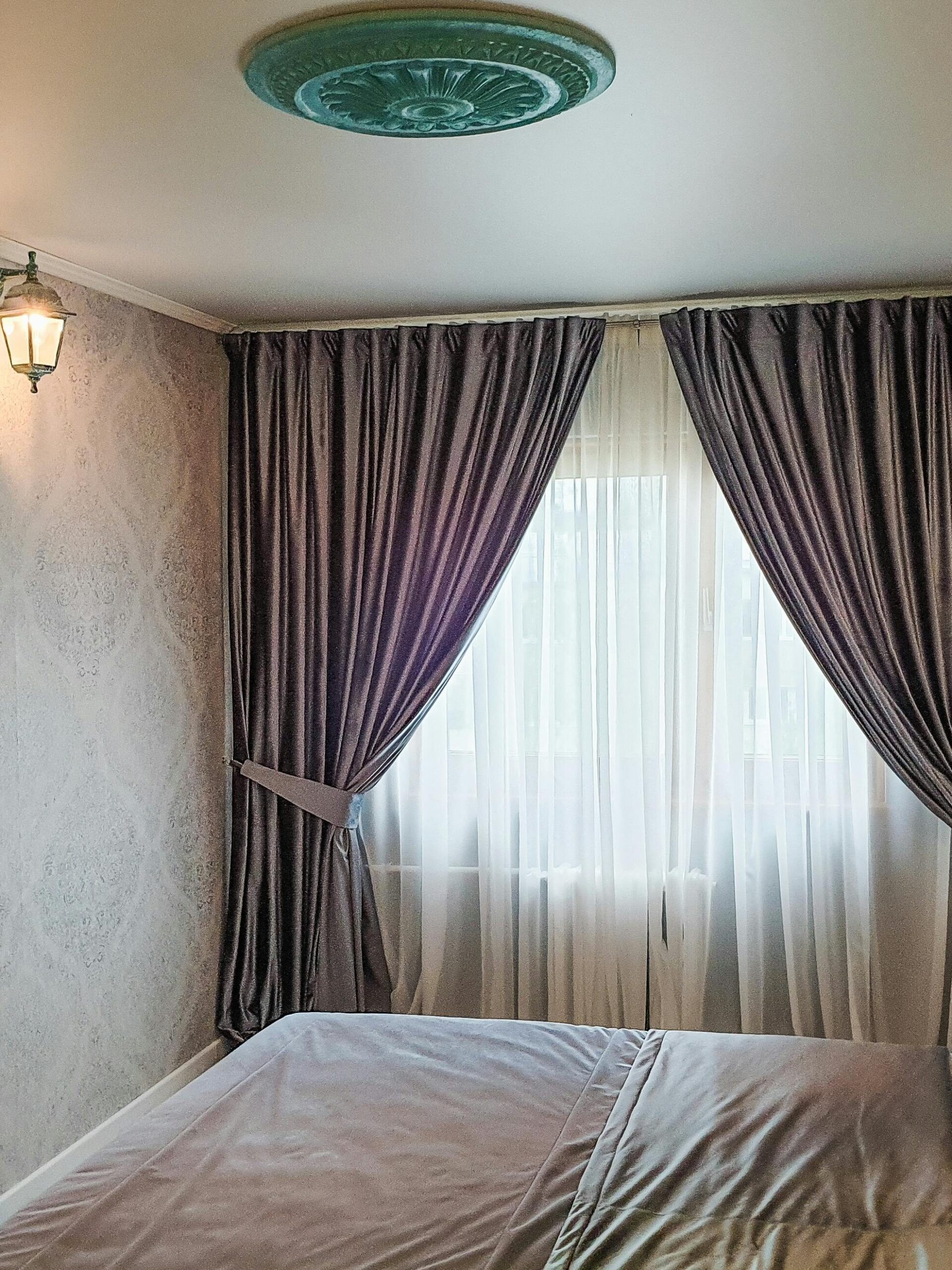 Ana Sayfa - Türkçe A serene bedroom featuring elegant curtains and classic wall sconces.